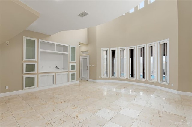 unfurnished living room with a towering ceiling