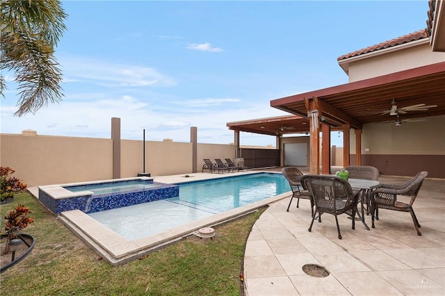 view of swimming pool with ceiling fan, a patio area, and an in ground hot tub