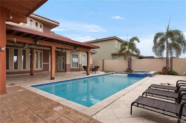 view of pool with an in ground hot tub, a patio, and ceiling fan