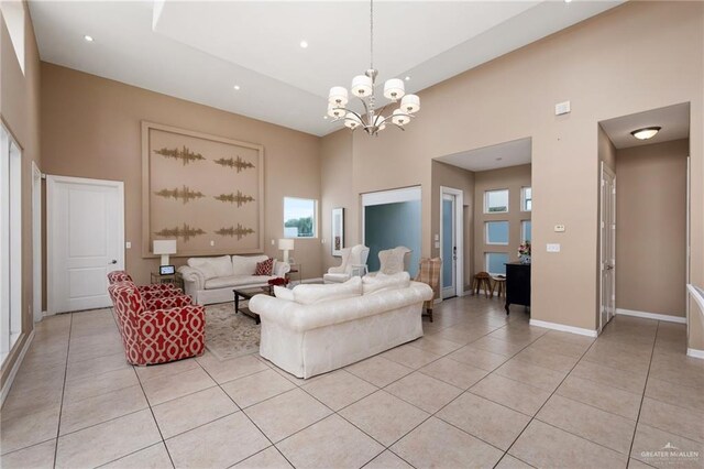 tiled living room featuring a towering ceiling and an inviting chandelier