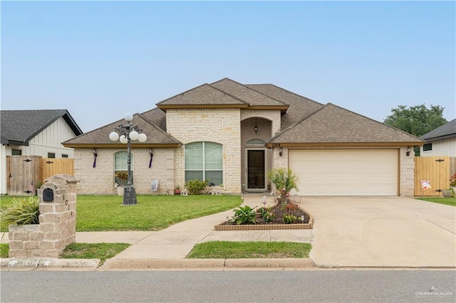 1014 Emerald Dr, Weslaco, TX 78599 - french country inspired facade with a garage, driveway, roof with shingles, and brick siding