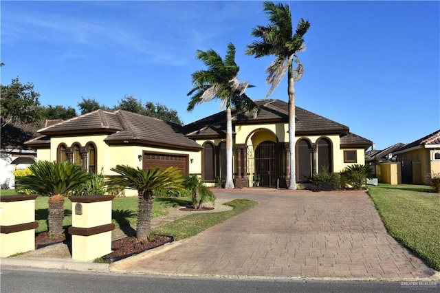 mediterranean / spanish-style home featuring a garage and a front yard