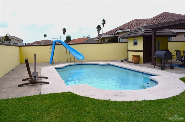 view of swimming pool with a water slide and a patio