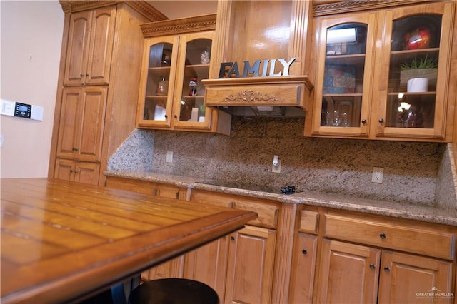 kitchen with backsplash, black electric cooktop, and butcher block counters