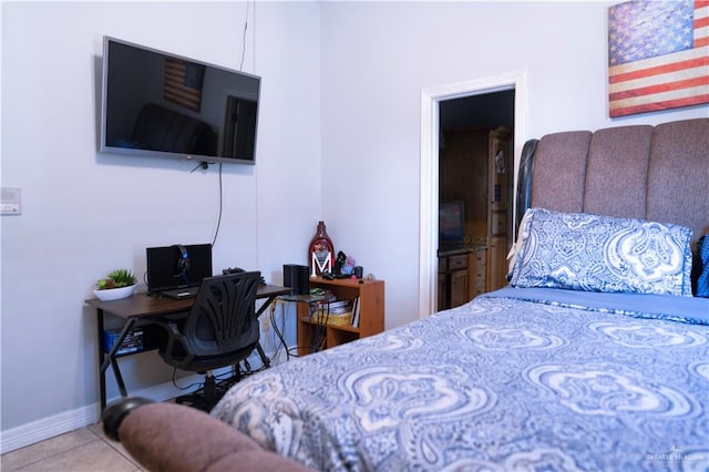 bedroom with light tile patterned floors and connected bathroom