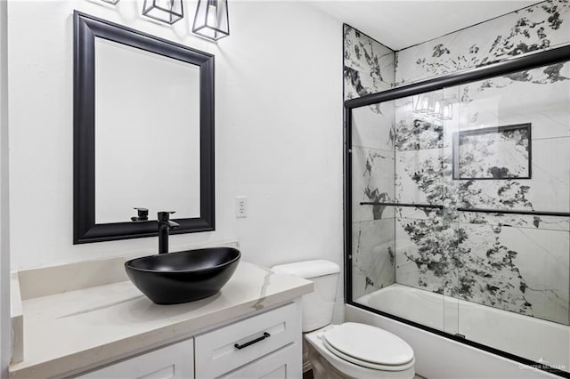 full bathroom with vanity, toilet, and bath / shower combo with glass door