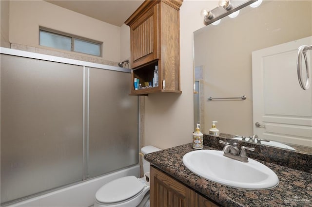 full bathroom with vanity, shower / bath combination with glass door, and toilet