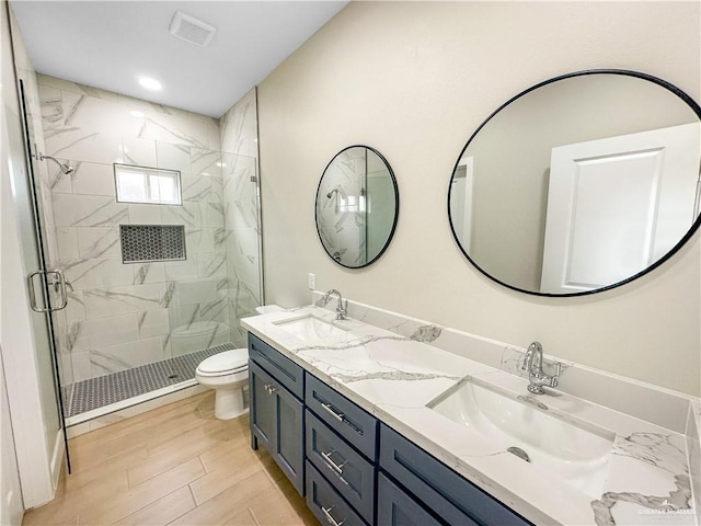 full bath with wood finished floors, a sink, toilet, and a shower stall