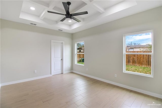 spare room featuring light wood finished floors, baseboards, visible vents, and coffered ceiling