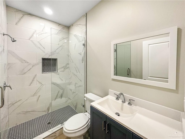 full bathroom featuring a shower stall, toilet, and vanity