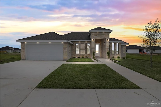 907 39th St, San Juan, TX 78516 - view of front facade featuring a garage, a front lawn, driveway, and stone siding