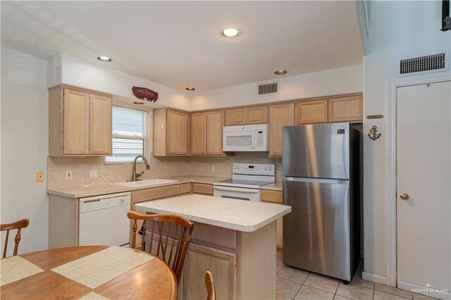 kitchen with light brown cabinets, sink, a center island, white appliances, and light tile patterned floors