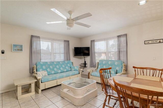 tiled living room with plenty of natural light and ceiling fan