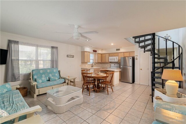 living room with ceiling fan, sink, and light tile patterned floors