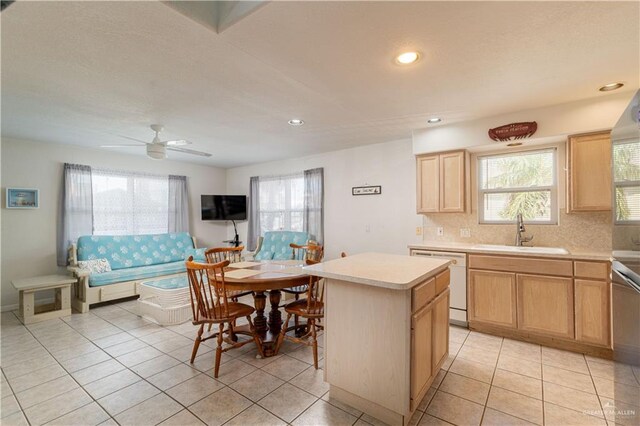 kitchen featuring ceiling fan, dishwasher, sink, a center island, and light tile patterned floors