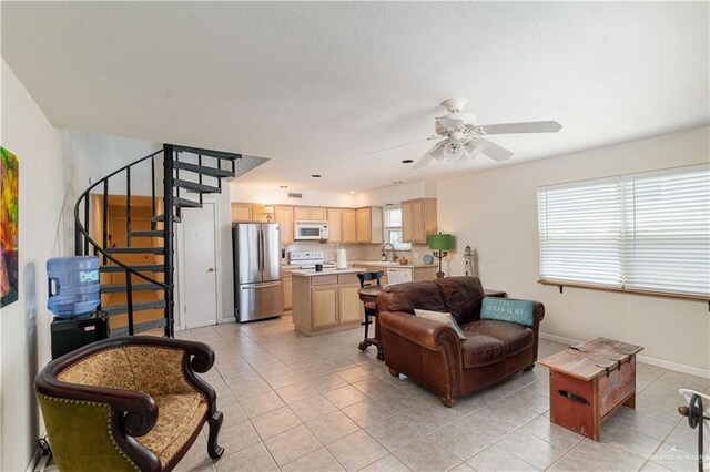 living room with ceiling fan, sink, and light tile patterned flooring