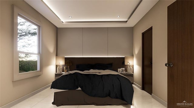 bedroom with light tile patterned floors, a tray ceiling, and baseboards