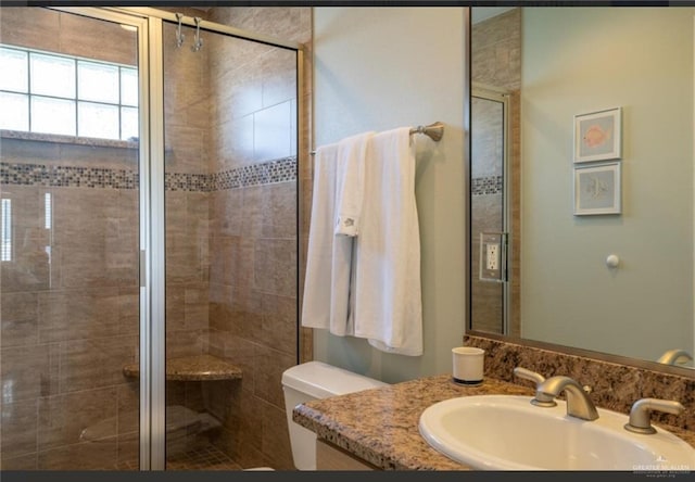 bathroom featuring vanity, toilet, and walk in shower