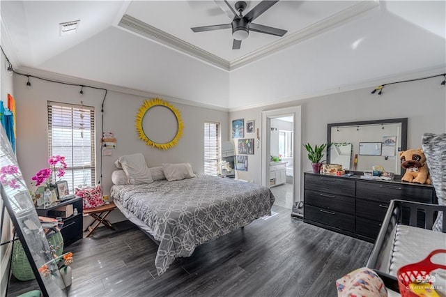 bedroom with ceiling fan, dark wood-type flooring, ensuite bathroom, a tray ceiling, and ornamental molding