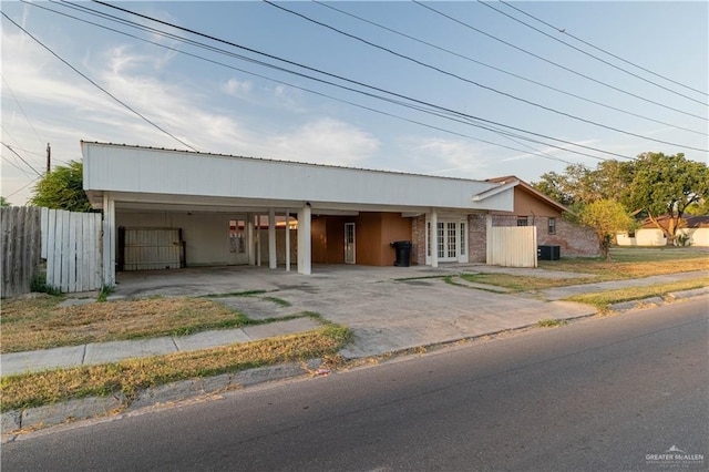 view of front of home featuring a carport, central air condition unit, and french doors