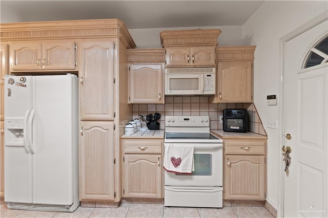 kitchen with light tile patterned flooring, light brown cabinetry, tasteful backsplash, and white appliances