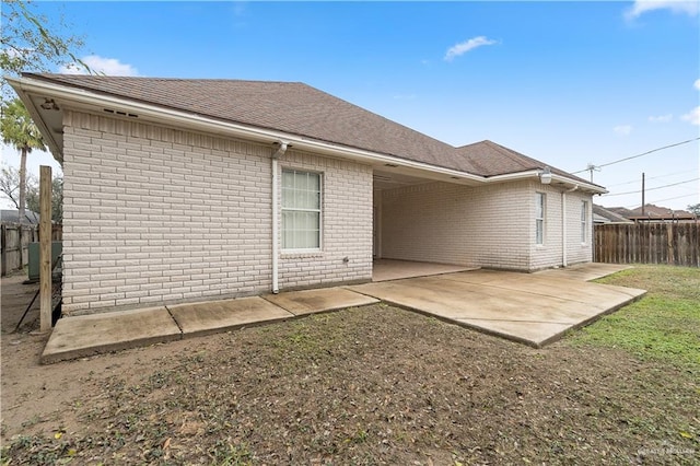 rear view of house featuring a patio area and a yard