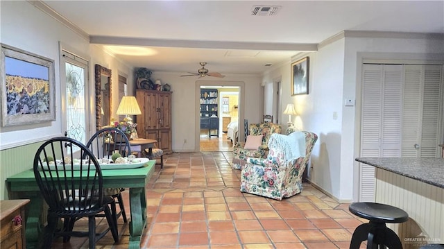 tiled living room featuring ceiling fan, ornamental molding, and radiator heating unit