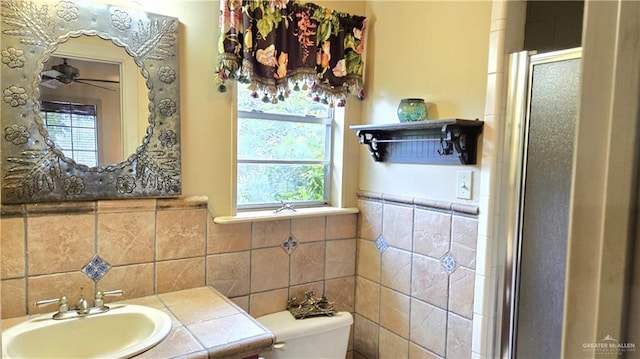 bathroom with toilet, ceiling fan, an enclosed shower, and vanity