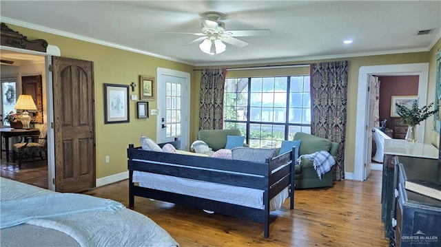 bedroom with ceiling fan, ornamental molding, and wood-type flooring