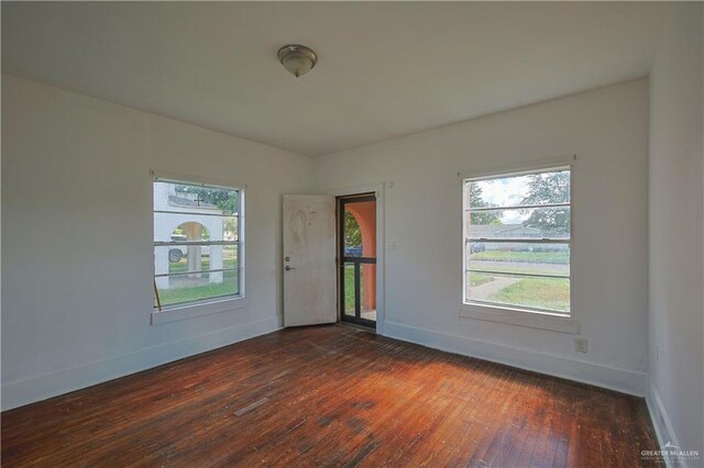 unfurnished room with dark hardwood / wood-style flooring