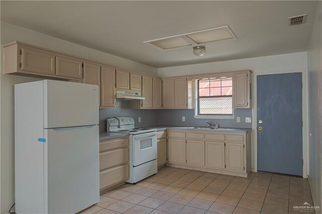 kitchen with white appliances, sink, and light tile patterned floors