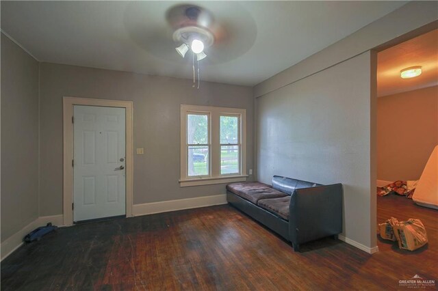 living room featuring ceiling fan and dark hardwood / wood-style flooring