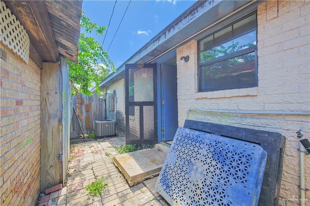 view of side of home with cooling unit and a patio