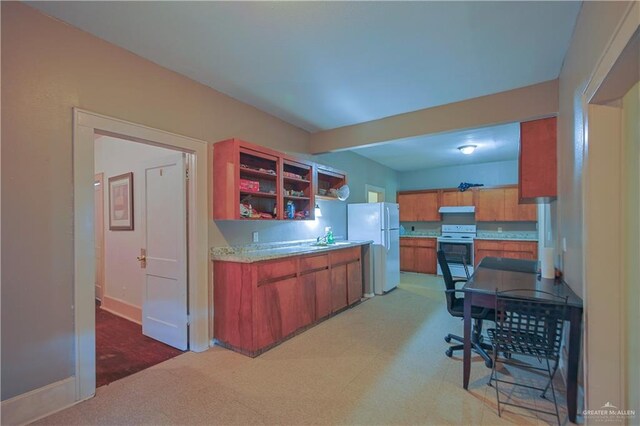 kitchen with sink, carpet, and white appliances