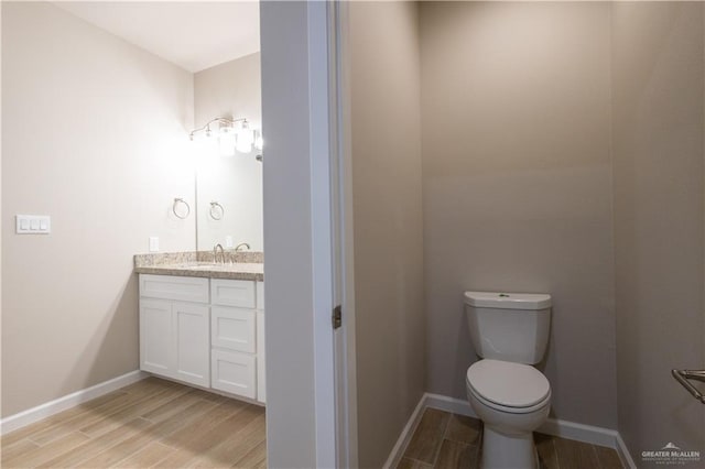 bathroom featuring hardwood / wood-style flooring, vanity, and toilet