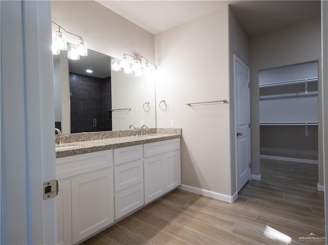 bathroom featuring a shower with door and vanity