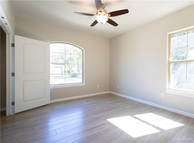 spare room with a wealth of natural light and light hardwood / wood-style flooring