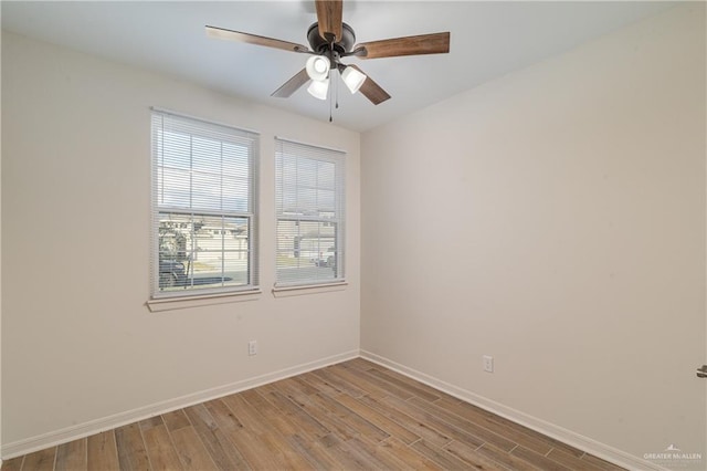 spare room featuring baseboards, ceiling fan, and light wood finished floors