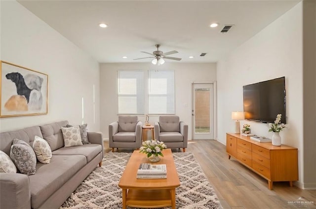 living area with light wood-type flooring, ceiling fan, visible vents, and recessed lighting