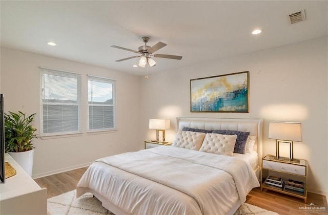 bedroom with baseboards, light wood finished floors, visible vents, and recessed lighting