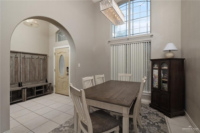 dining space with light tile patterned floors and a high ceiling