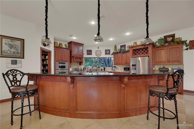 kitchen featuring a kitchen breakfast bar, a center island, stainless steel appliances, and hanging light fixtures