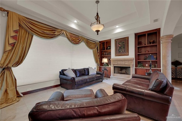 tiled living room with built in features and a tray ceiling