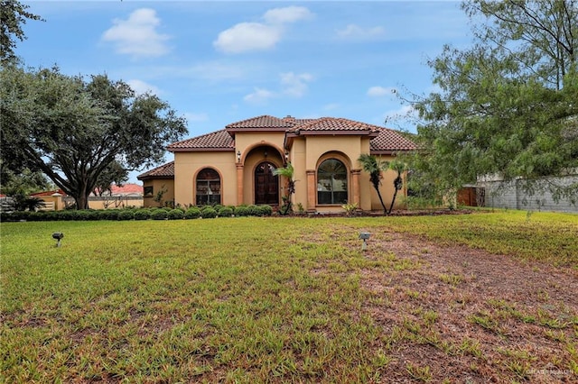 mediterranean / spanish-style home with a front lawn