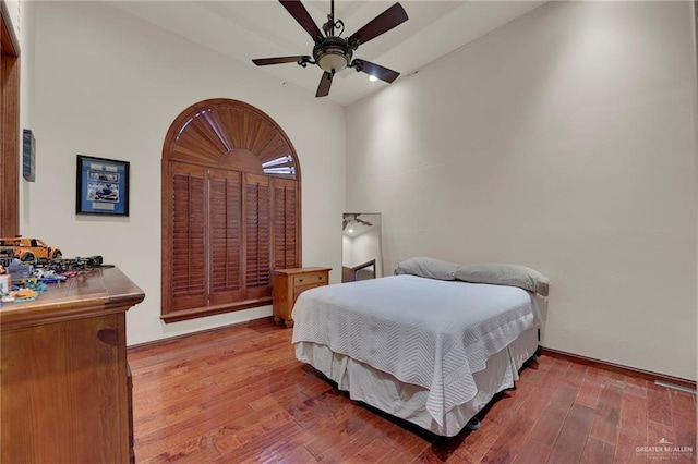 bedroom with a towering ceiling, light hardwood / wood-style floors, and ceiling fan