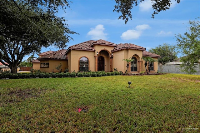 mediterranean / spanish home with a front yard