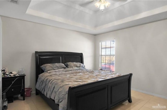 bedroom with a tray ceiling, ceiling fan, and light tile patterned flooring