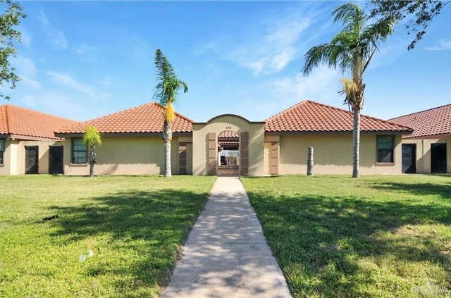 mediterranean / spanish-style house featuring a front lawn