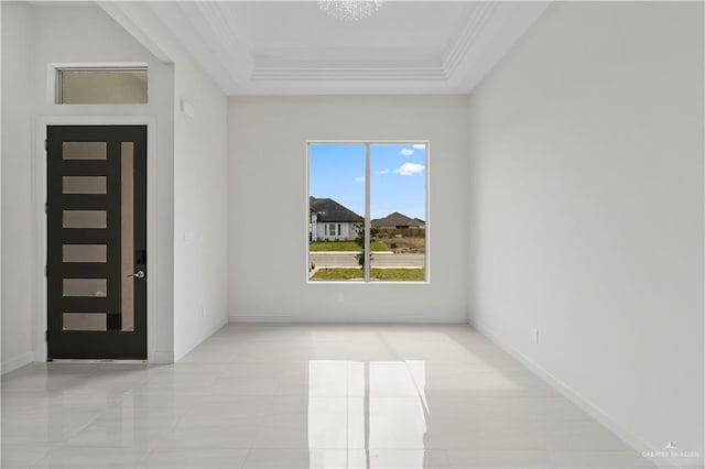 empty room featuring a tray ceiling and crown molding