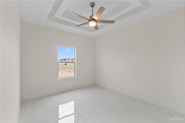 unfurnished room featuring a tray ceiling and ceiling fan